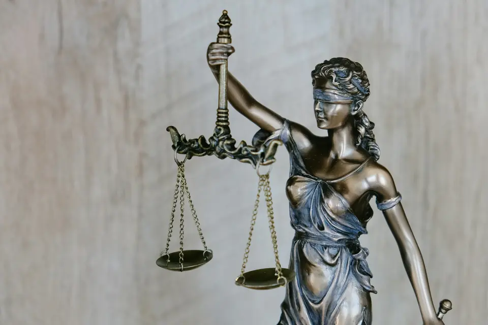 Bronsestatue av Justitia med bind for øynene og vektskål i hånden